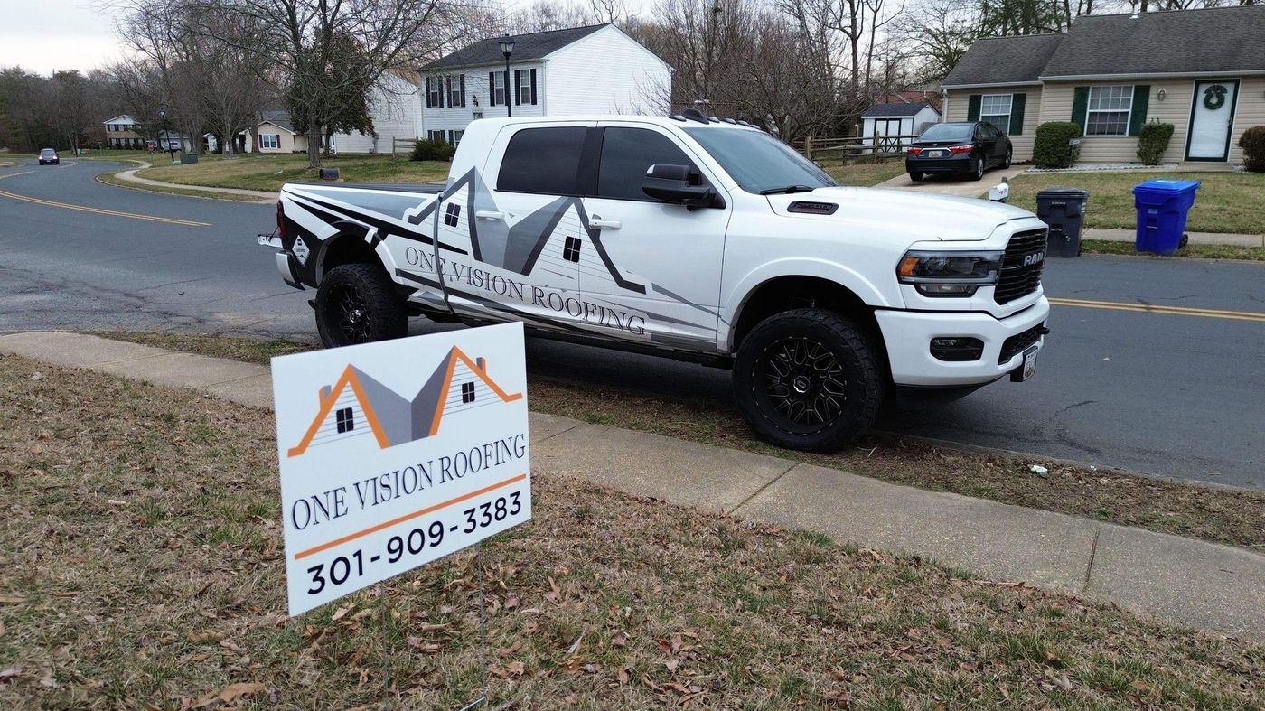 One Vision Roofing pickup truck with a company yard sign