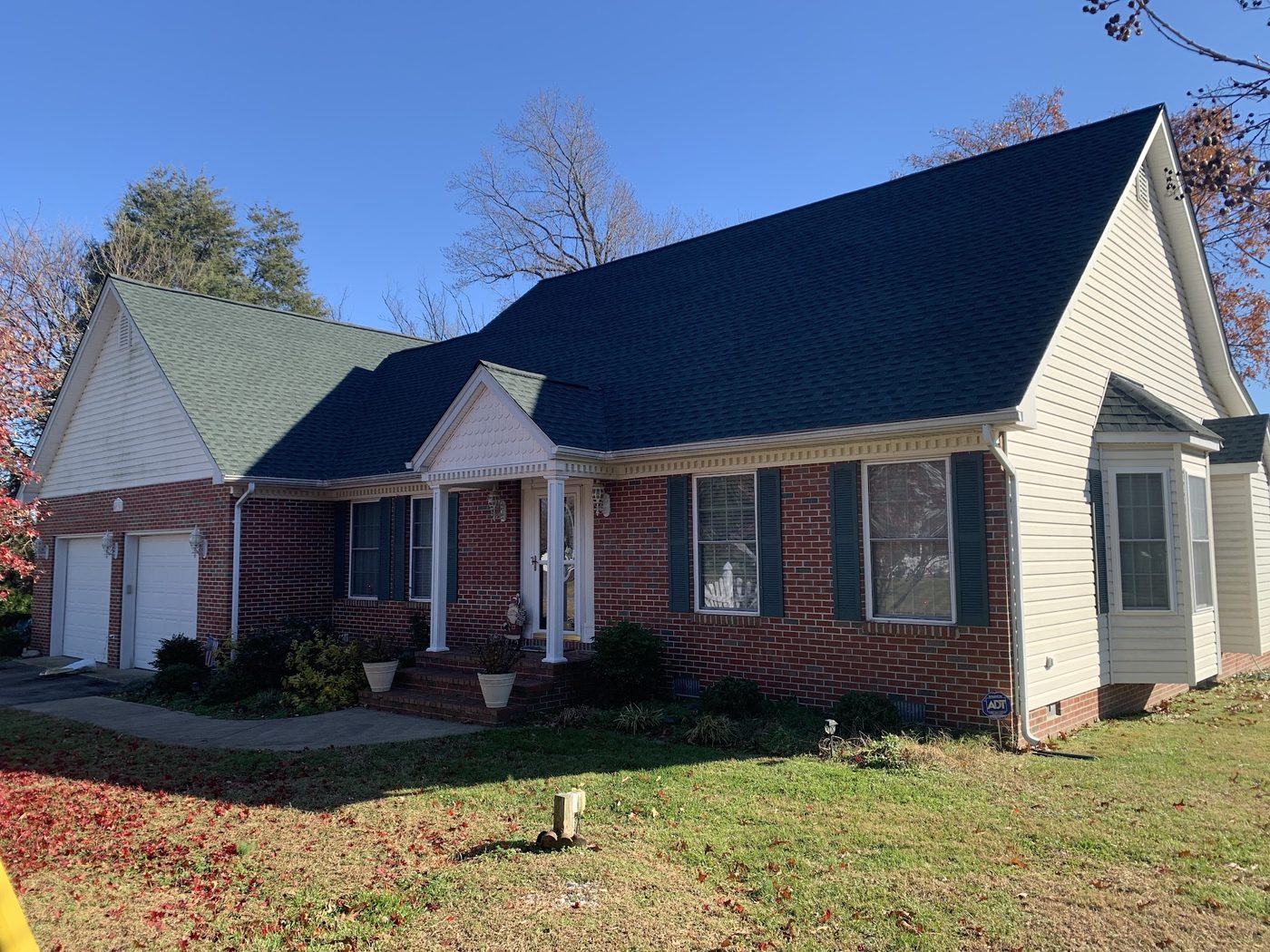 Brick and siding home with a new dark shingle roof and attached garage
