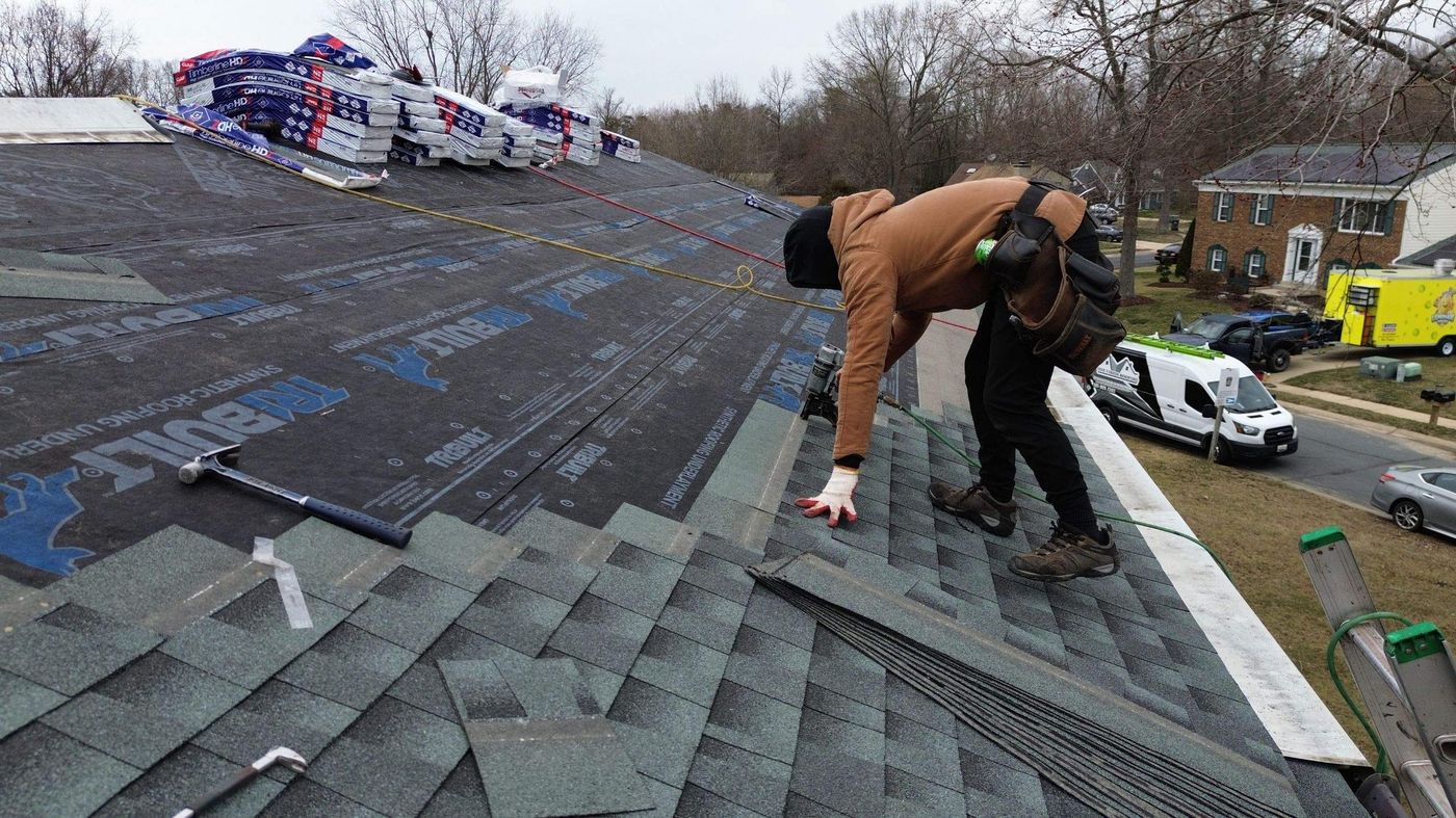 Roofer checking new shingles going on over underlayment