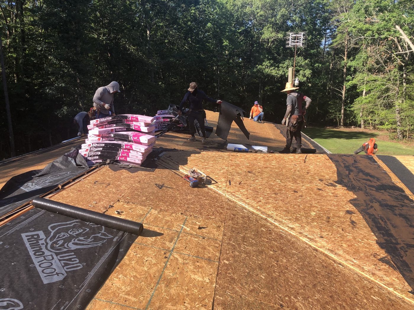 Crew putting down new decking and underlayment on a roof