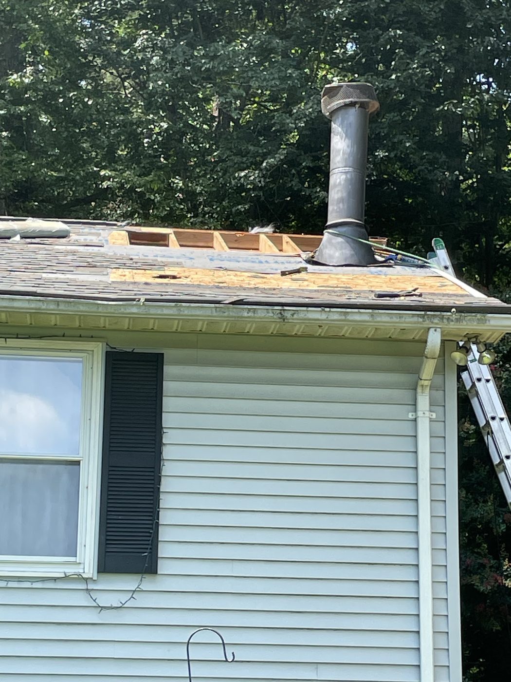 Section of roof opened up around a vent pipe for repair
