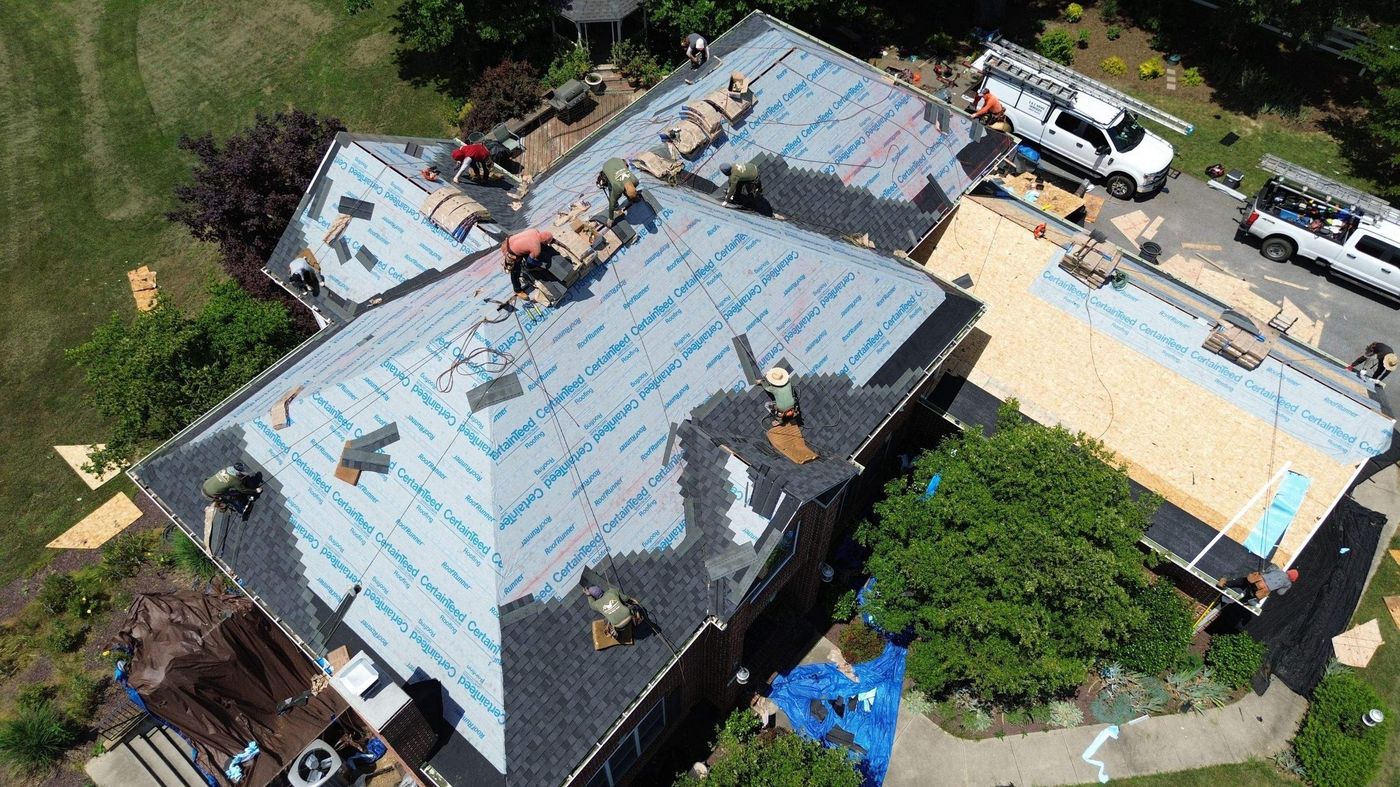 Old shingles stripped and new underlayment going down on a large roof
