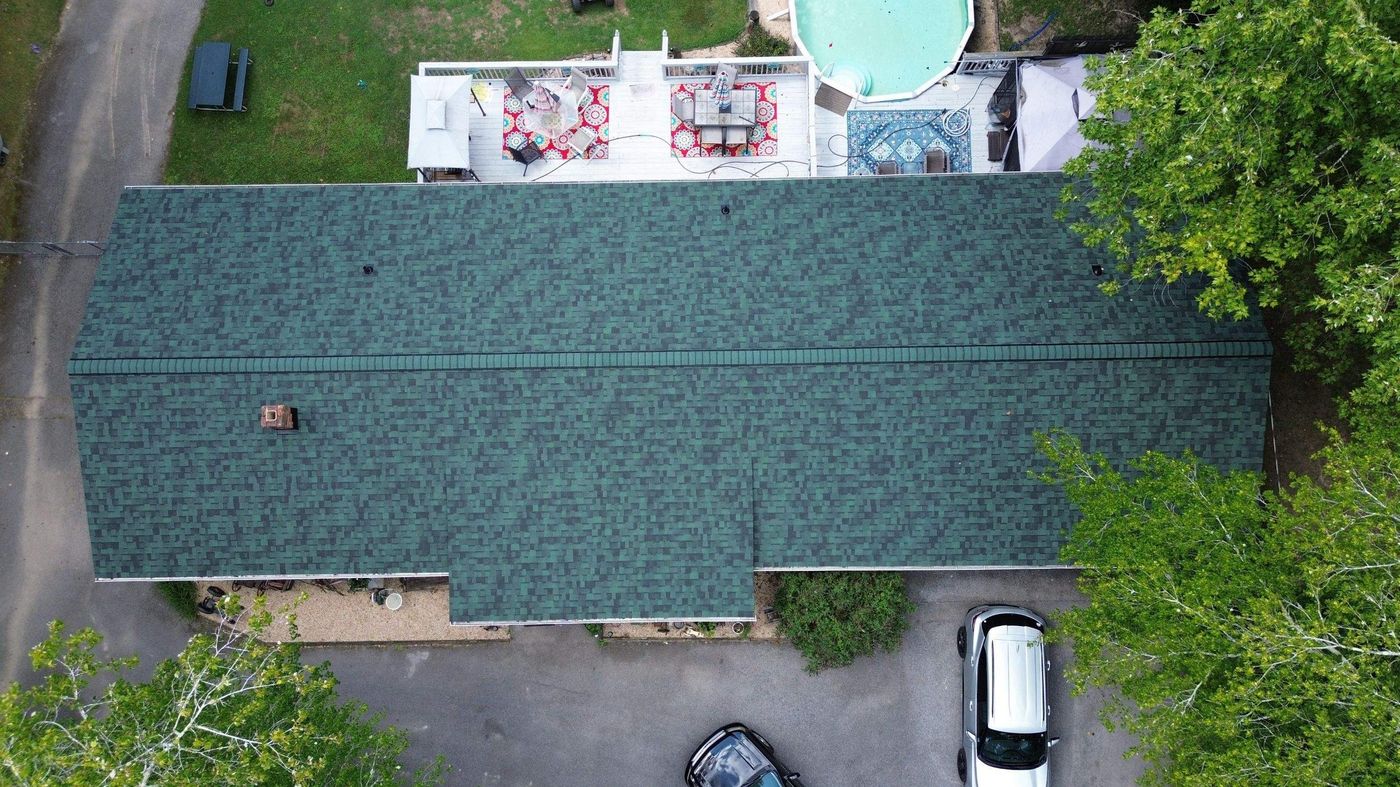 Aerial view of a new green shingle roof on a long single-story home