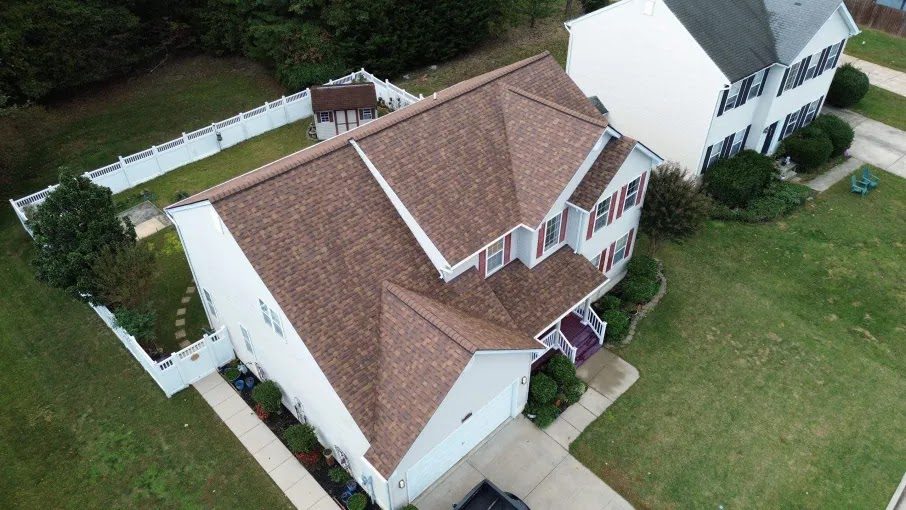 Front of a brick home with a newly installed dark shingle roof