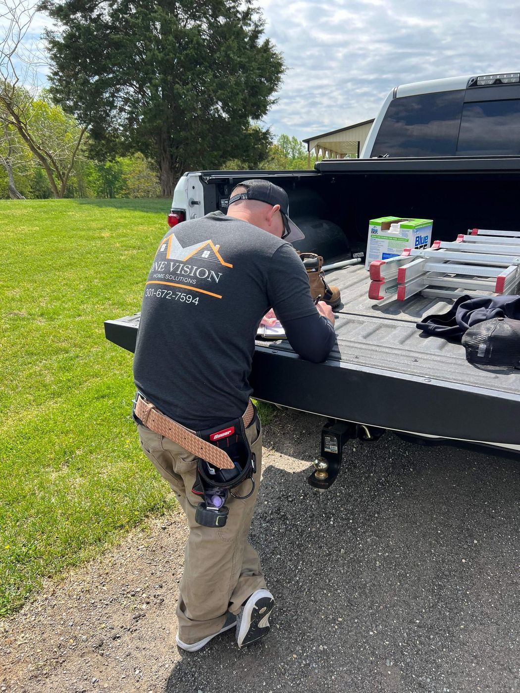 One Vision Roofing crew member unloading tools from a truck