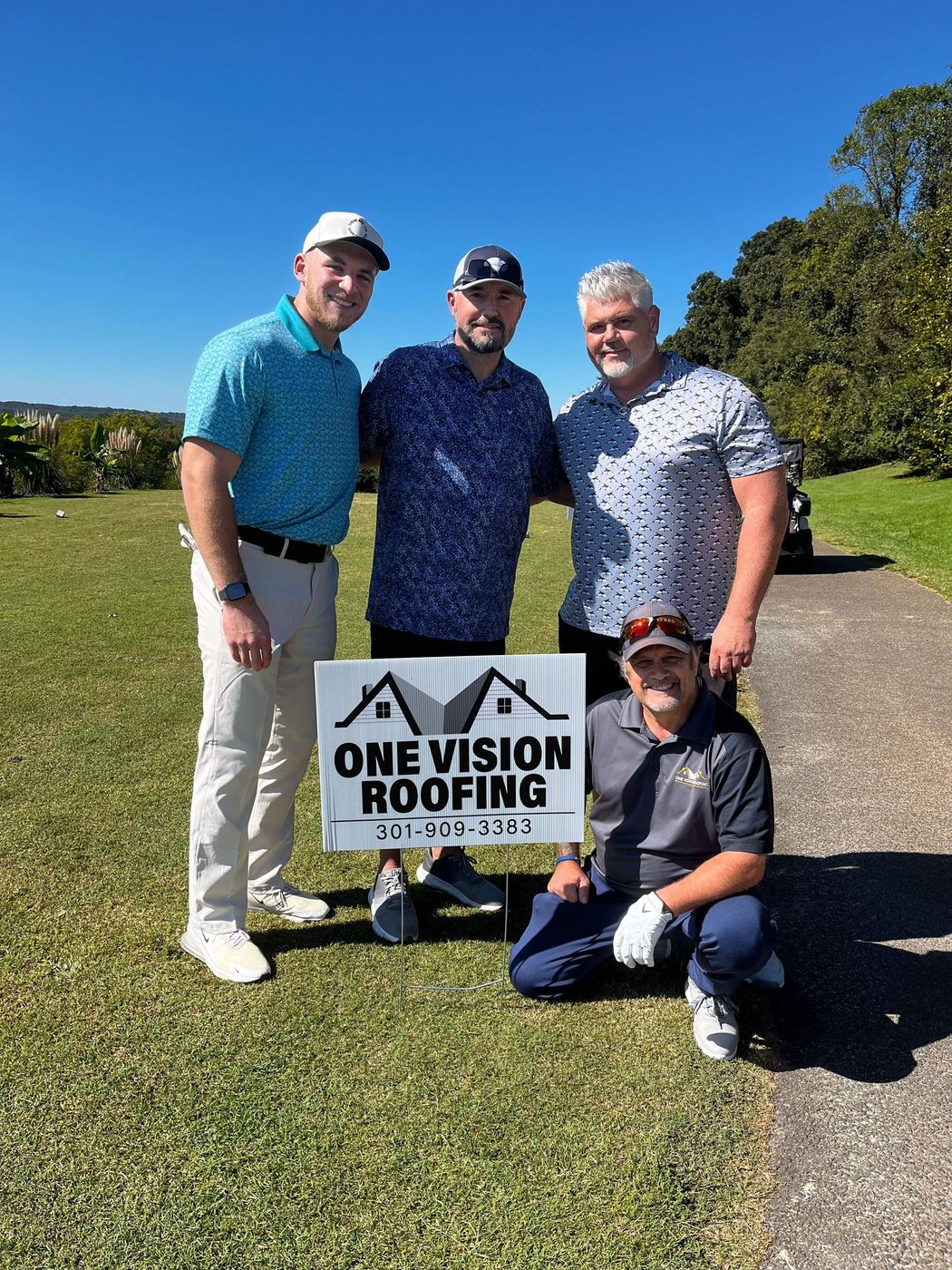One Vision Roofing team members with a yard sign