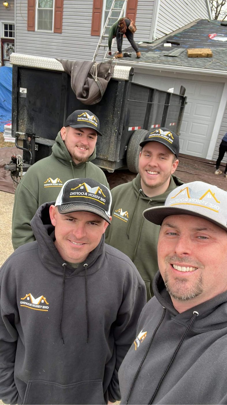 Four One Vision Roofing crew members in company hoodies